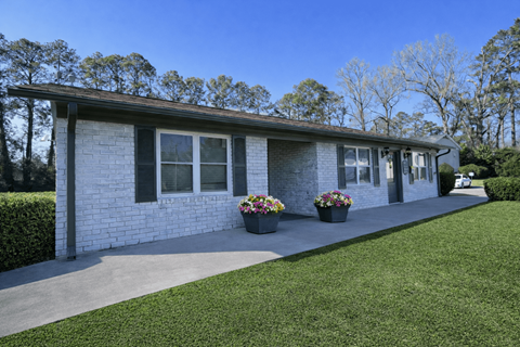 A house with a white brick exterior and a grey roof.