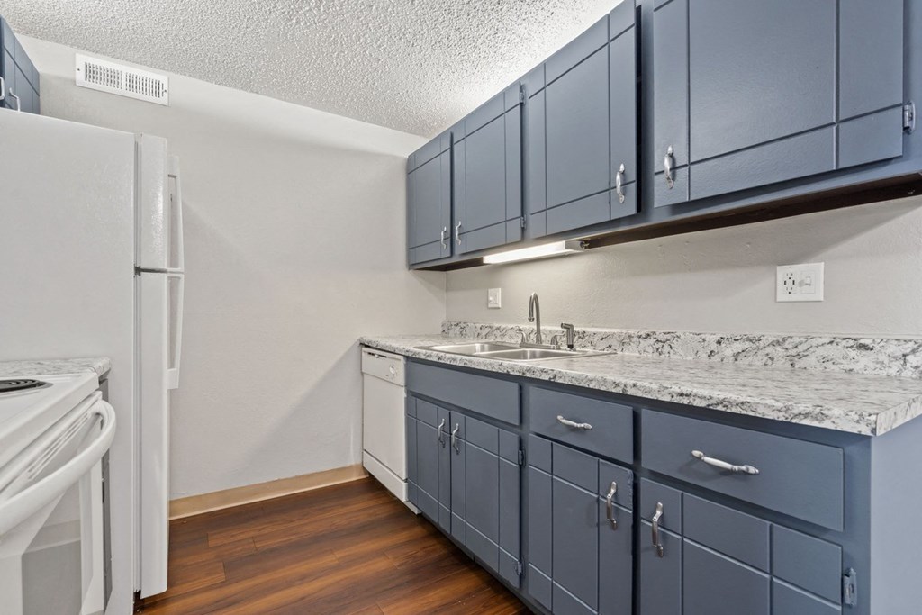 a kitchen with blue cabinets and a white refrigerator