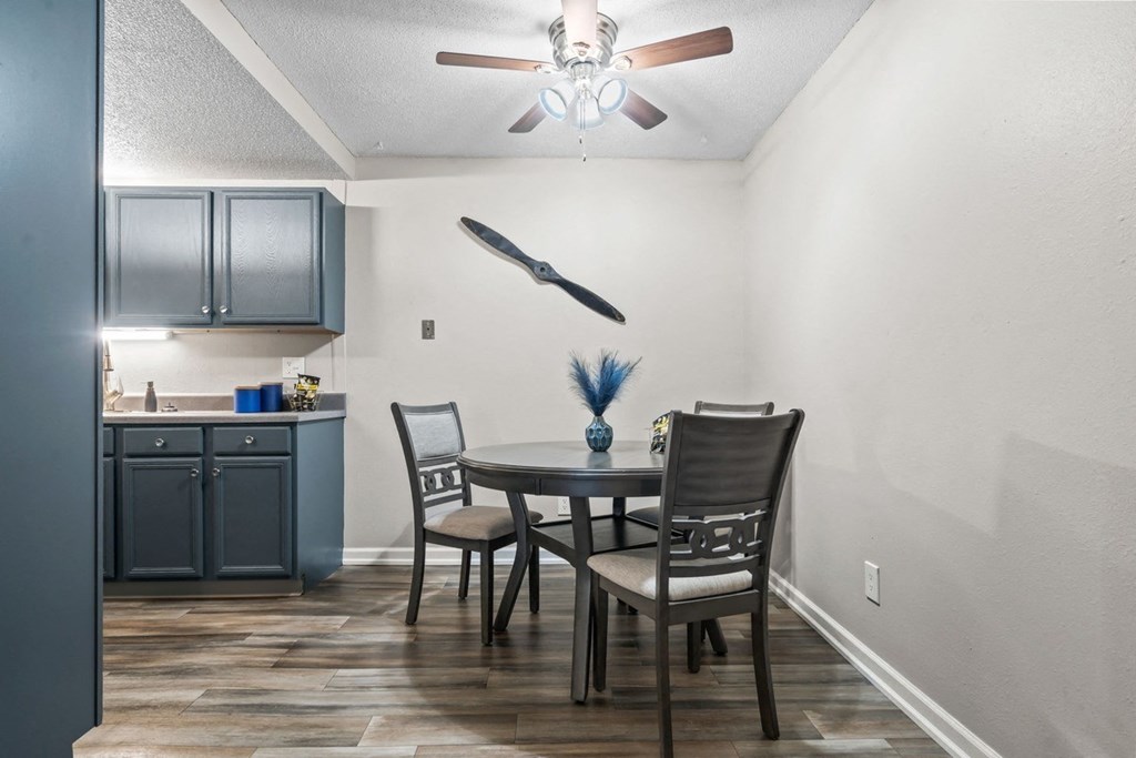 a dining room with a table and chairs and a ceiling fan