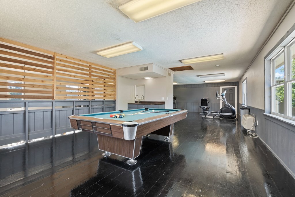 a game room with a pool table and a gym with a wheelchair