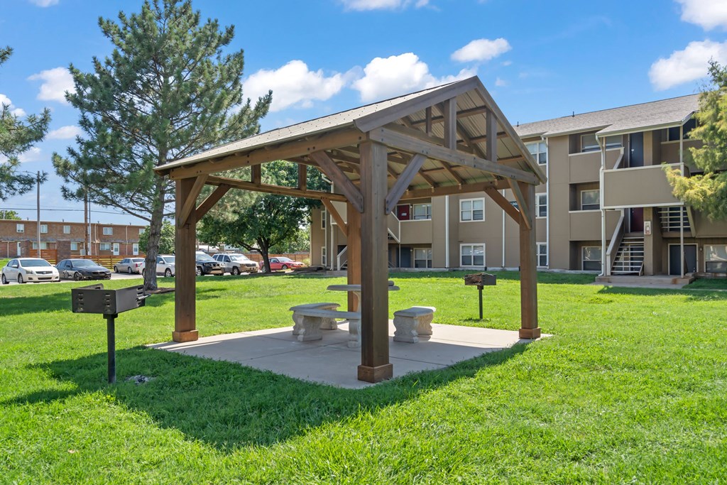 a picnic area with a bench in front of an apartment building