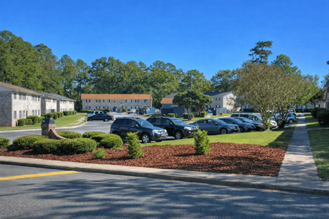 A street view of a residential area with cars parked on the side of the road.