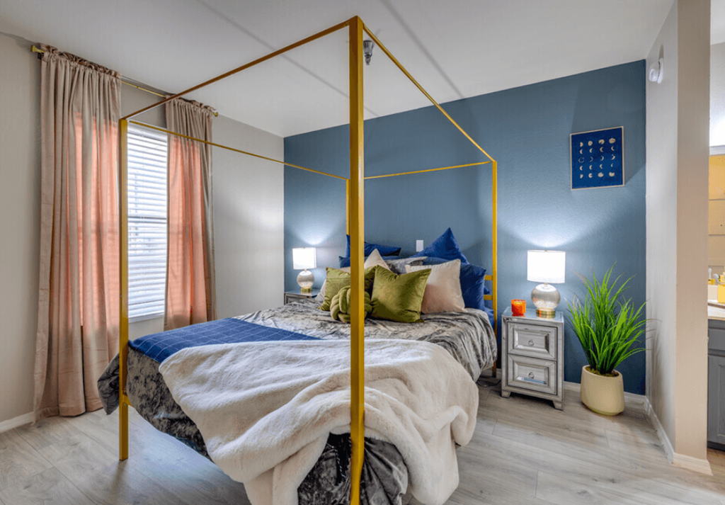a bedroom with a gold canopy bed a bedroom with a gold canopy bed at The Lodge Apartments, Tulsa