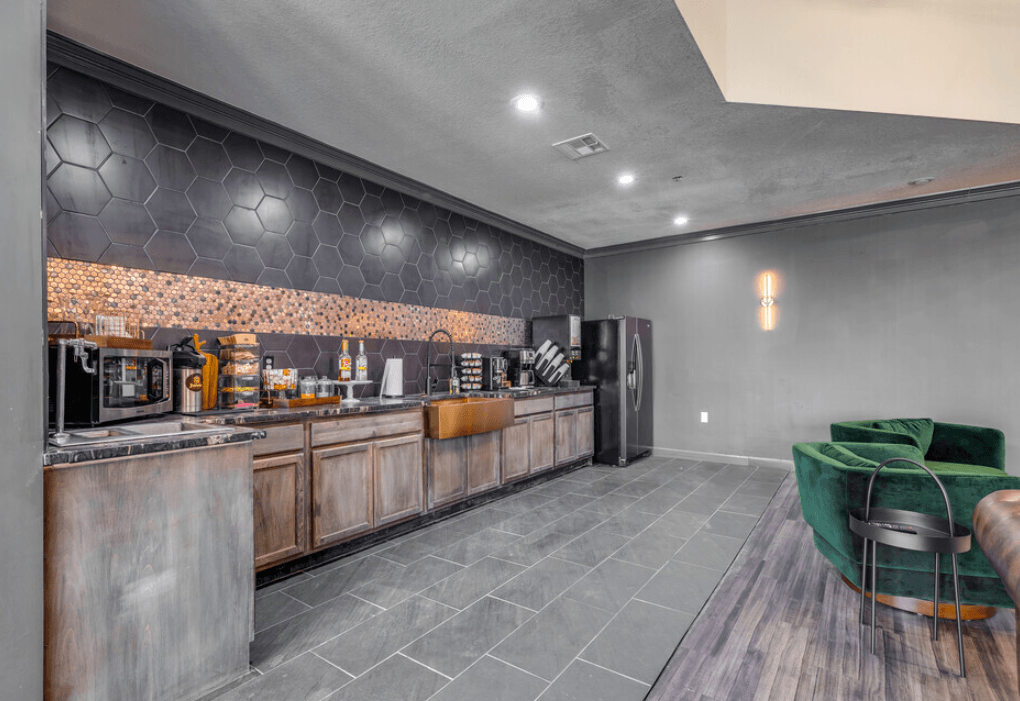 a clubhouse with a bar and a kitchen with a refrigerator at The Lodge Apartments, Tulsa, OK