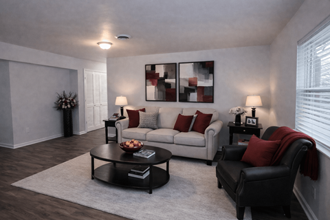 A living room with a grey couch, a black chair, and a coffee table.