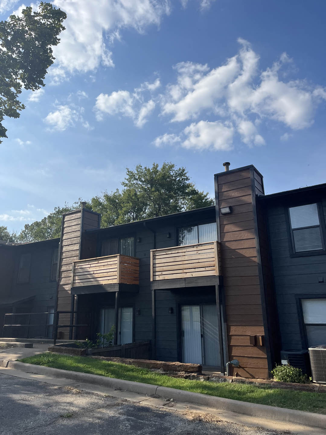 a picture of a black apartment building with a blue sky in the background at The Lodge Apartments, Tulsa Oklahoma