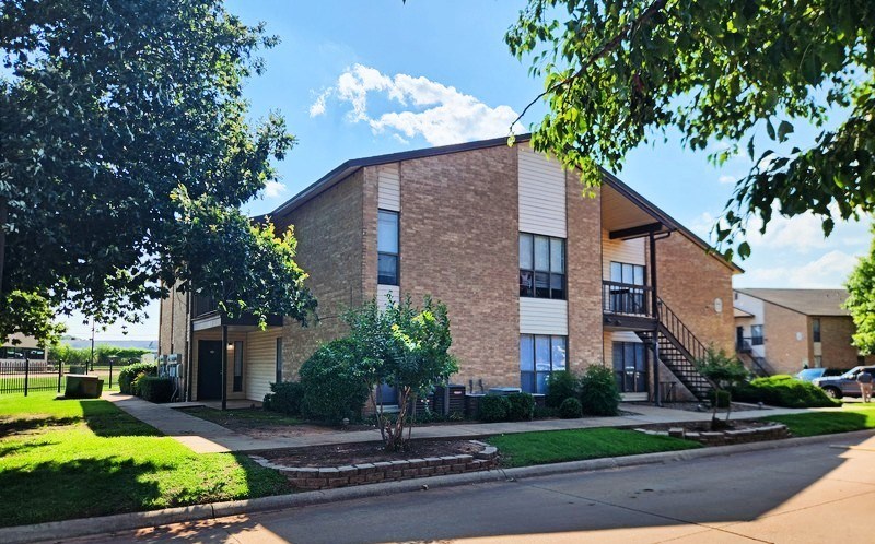 A modern brick building with a tree in front.