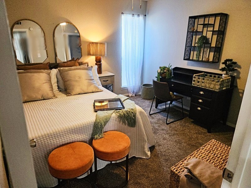 A bedroom with a bed, desk, and chair.