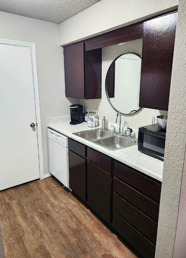 A small kitchen with a white door and a white sink.