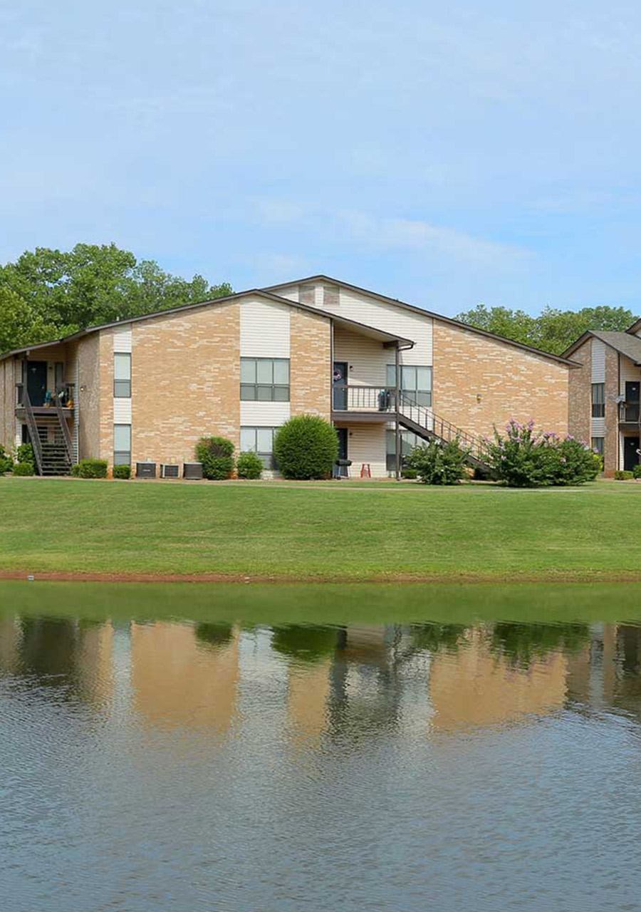 A building with a pond in front of it.