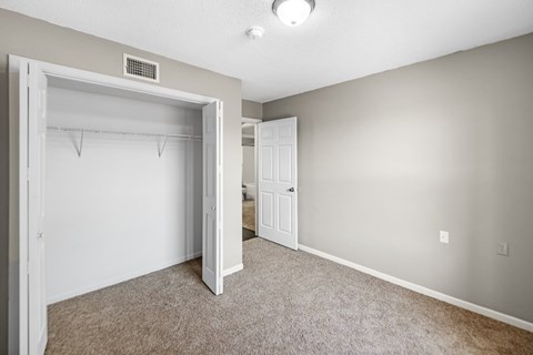 A room with a white door and a carpeted floor.