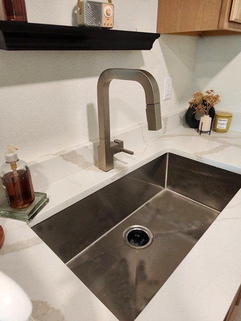 A modern kitchen sink with a chrome faucet.