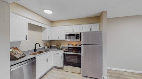 A kitchen with white cabinets and stainless steel appliances.