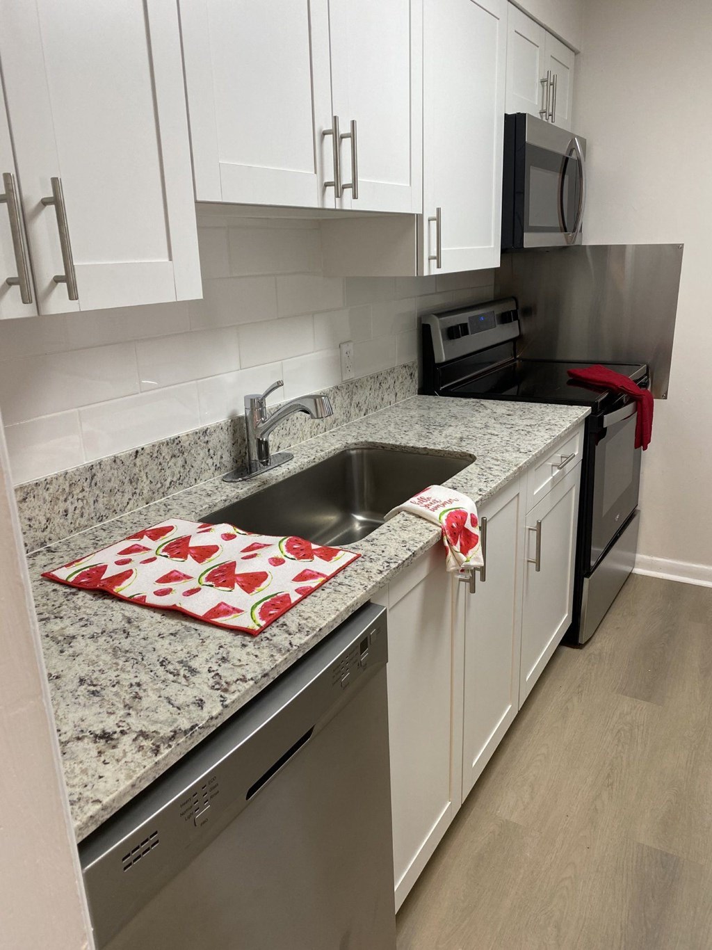 a kitchen with white cabinets and granite counter tops and a sink