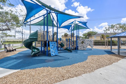 A playground with a blue slide and a green slide.
