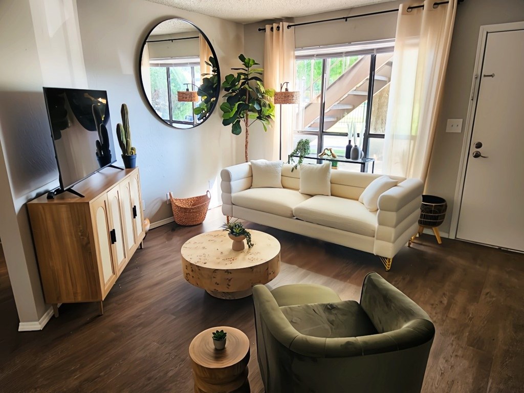 A living room with a white couch and a wooden coffee table.