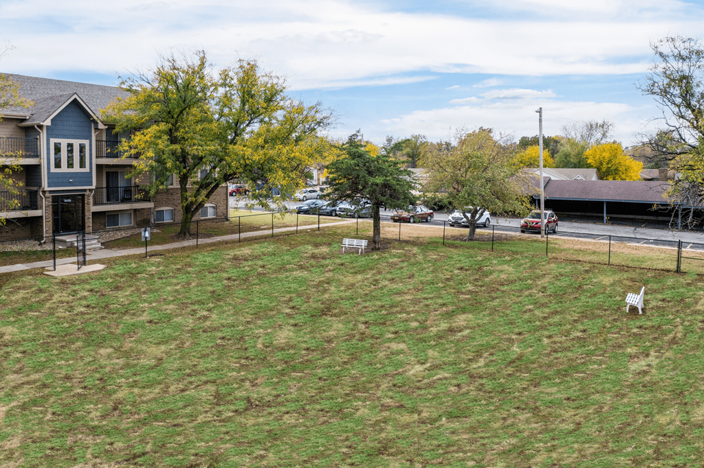 A grassy field with a white chair in the middle.