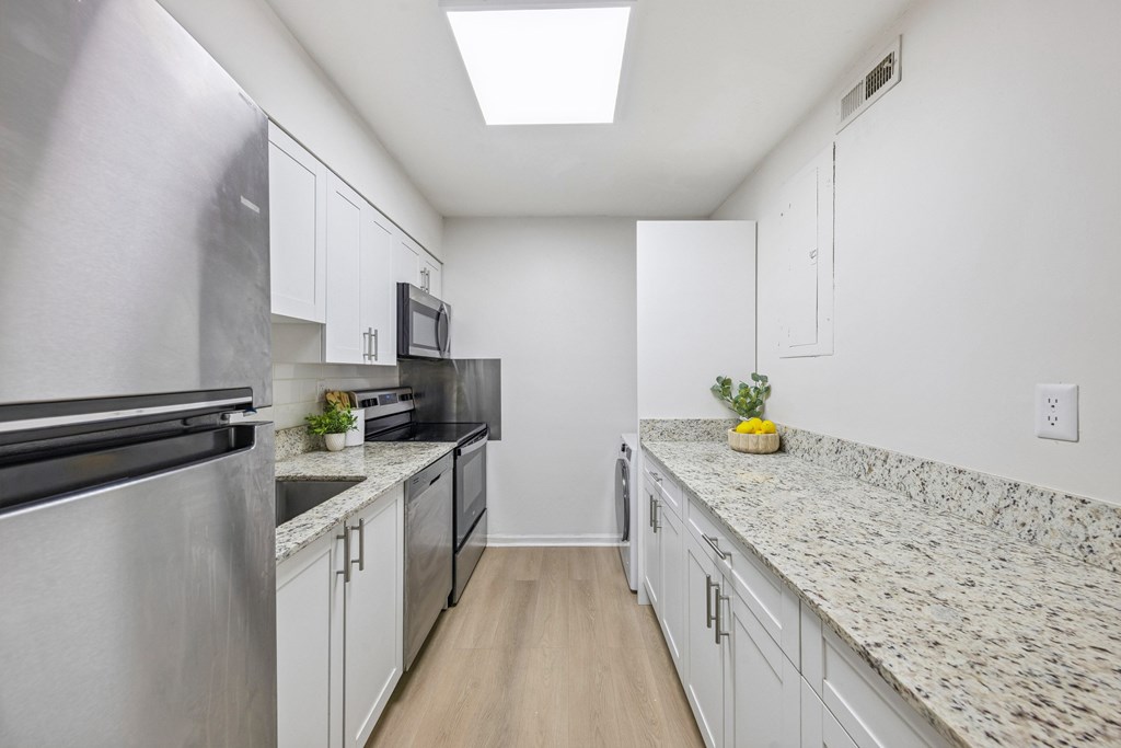 A kitchen with granite countertops and stainless steel appliances.