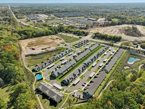 A bird's eye view of a residential area with houses and a swimming pool.