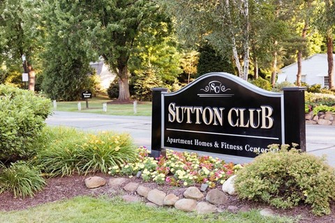 A sign for Sutton Club Apartment Homes & Fitness Center.