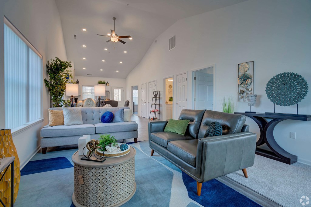 A living room with a grey couch and a round table.