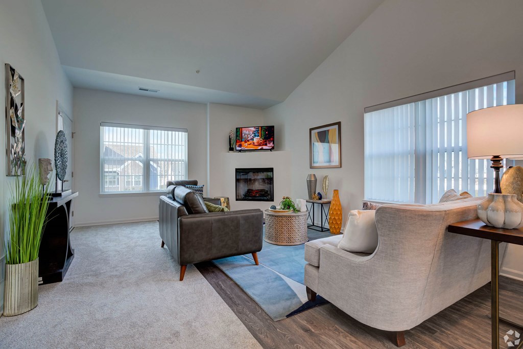 A living room with a grey couch and a fireplace.