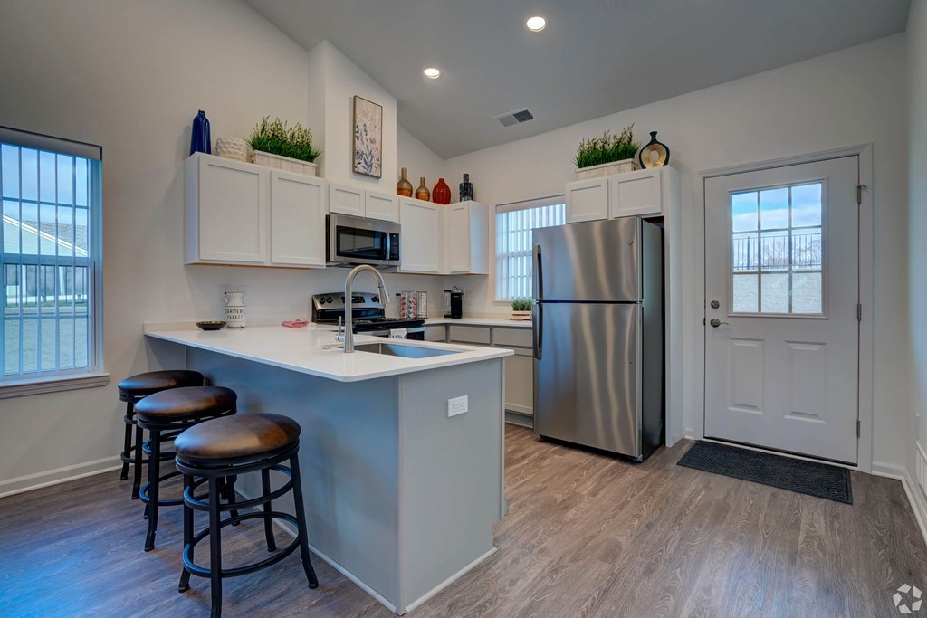 A kitchen with a white counter and stainless steel appliances.