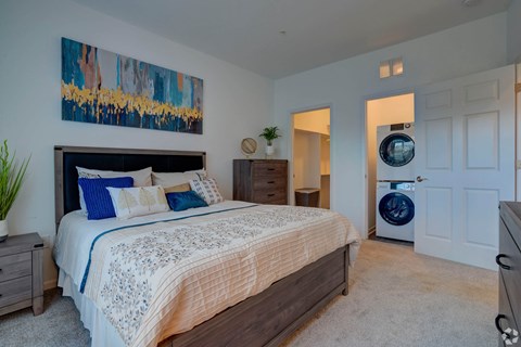 A bedroom with a large bed and a painting on the wall.