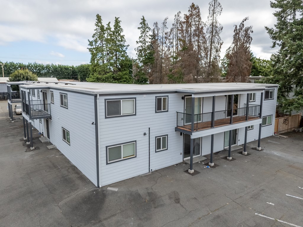 A white mobile home with a balcony and a deck.