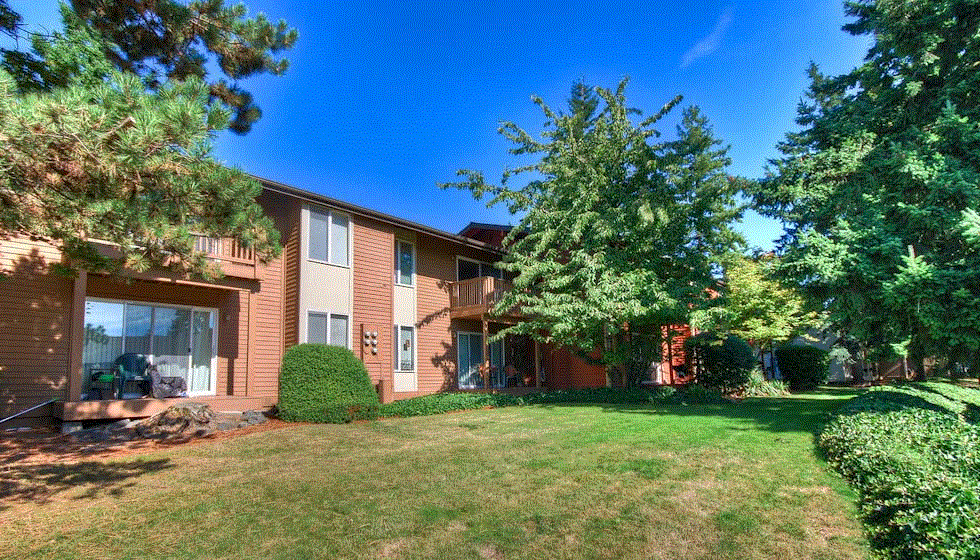 the exterior of a house with a lawn and trees