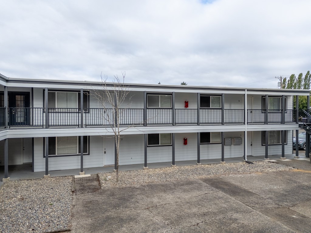 A building with a grey facade and a tree in front.