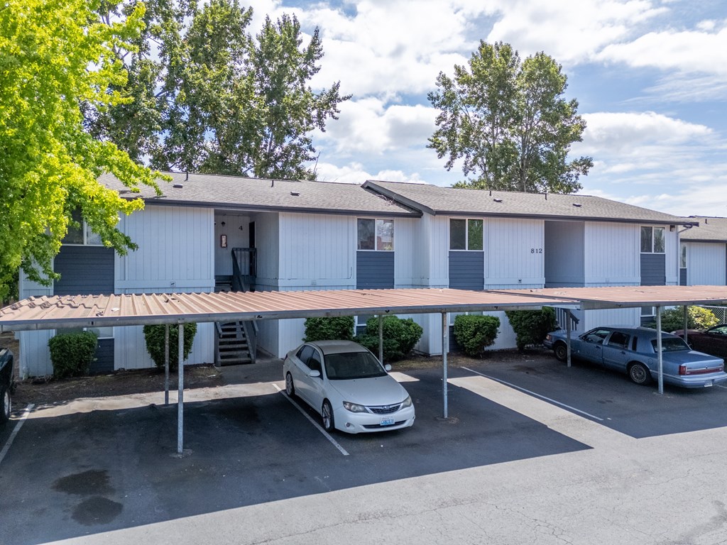 A carport with a white car parked under it.