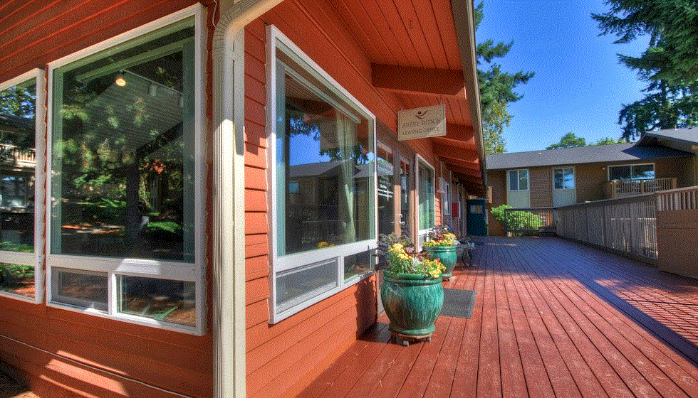 the front porch of a wooden building with potted plants