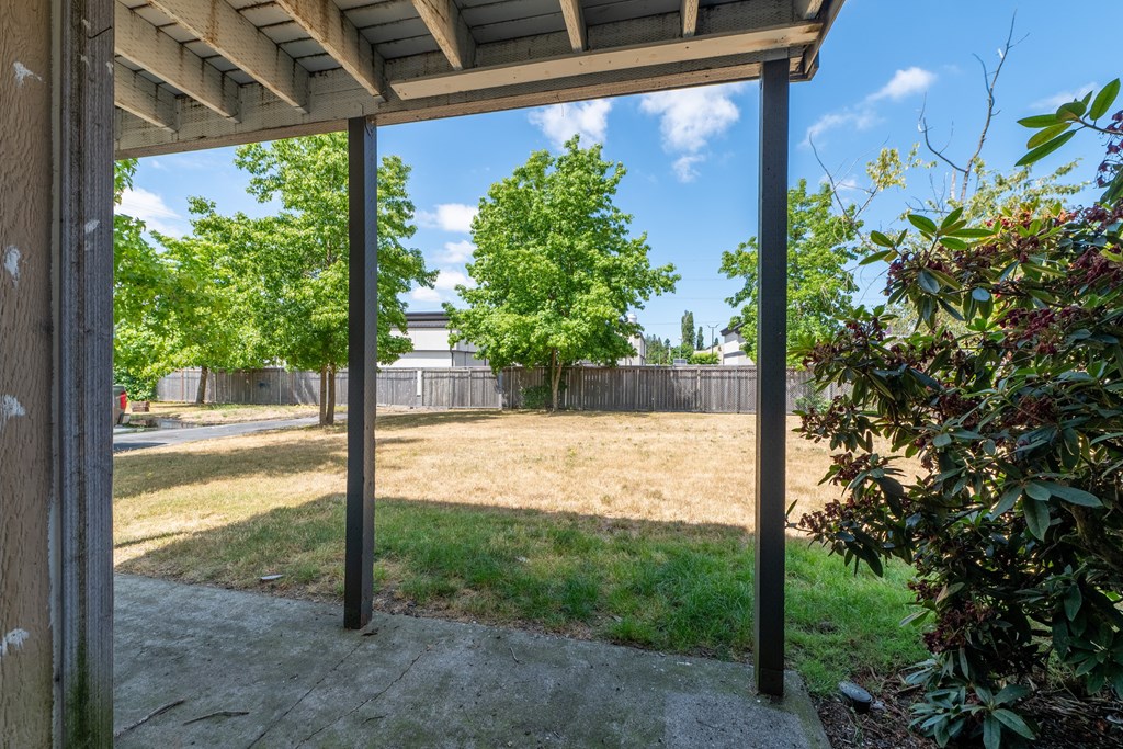 A patio with a roof and a concrete floor.