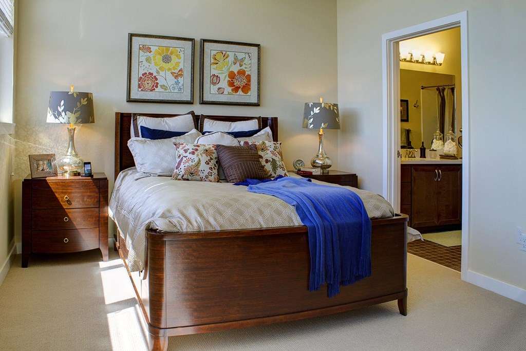 a bedroom with a bed and two nightstands and a mirror