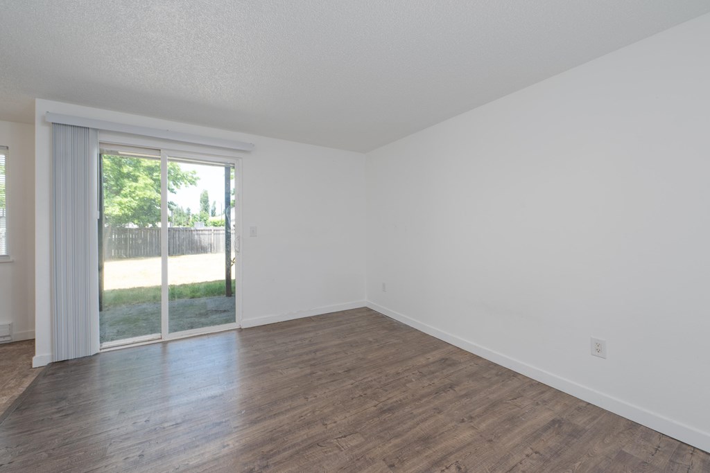 A room with a sliding glass door leading to a backyard.