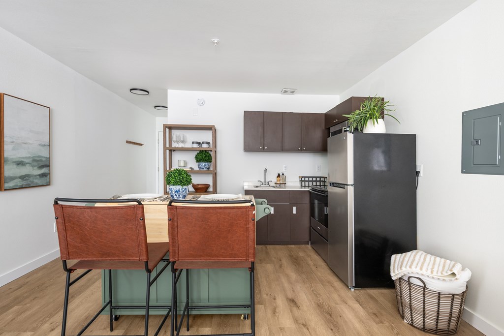 A kitchen with a table and chairs and a refrigerator.