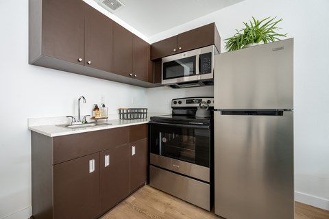 A modern kitchen with a stainless steel refrigerator, oven, and microwave.