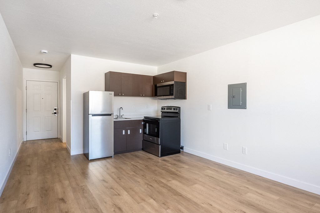 A kitchen with a refrigerator, microwave, and oven.