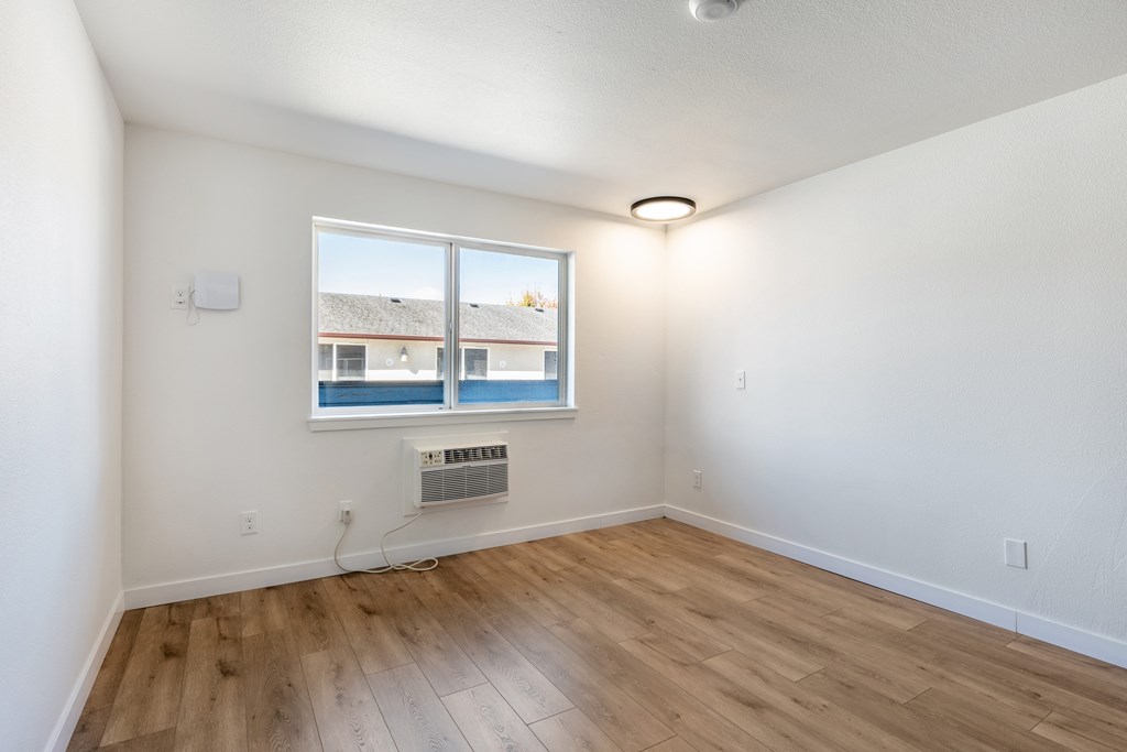 A room with a window and a fan on the wall.