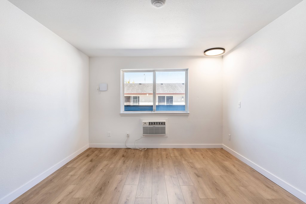A room with a window and a fan on the ceiling.