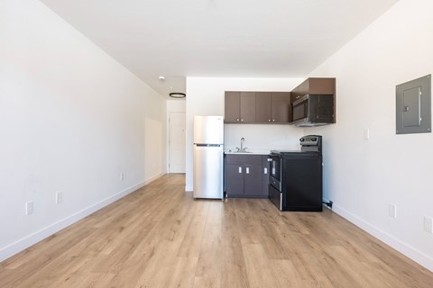 A kitchen with a black fridge and microwave.