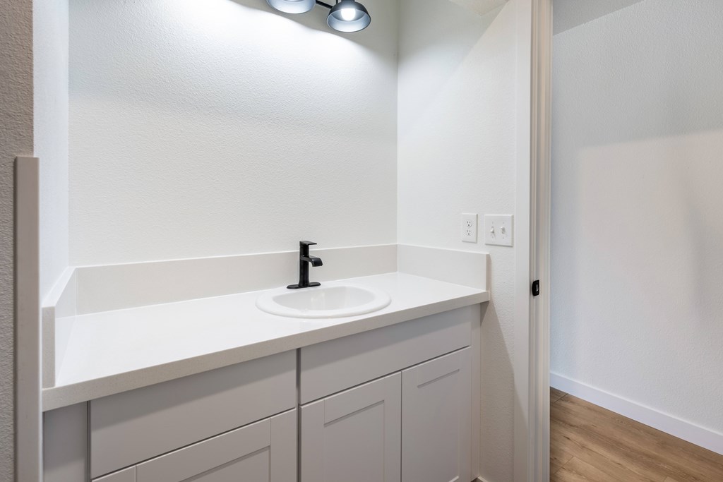 A bathroom with a sink and a mirror.