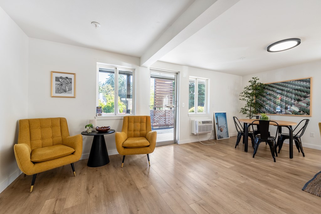 A living room with yellow chairs and a black table.