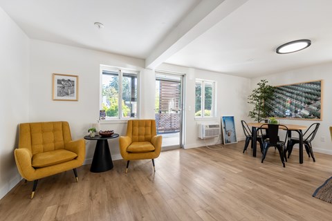 A living room with yellow chairs and a black table.