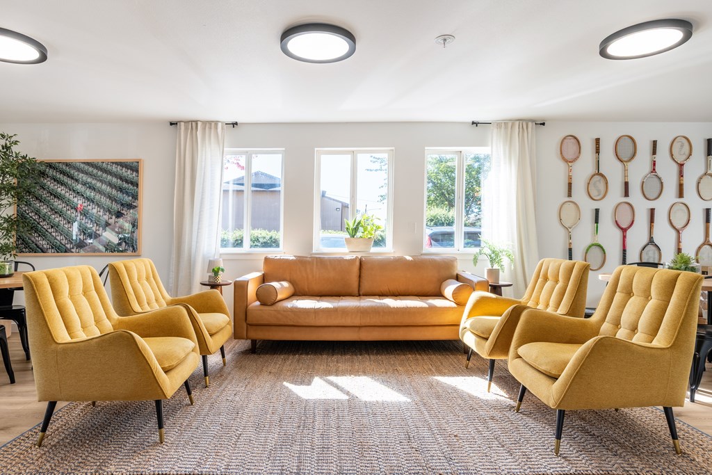 A living room with yellow chairs and a brown sofa.