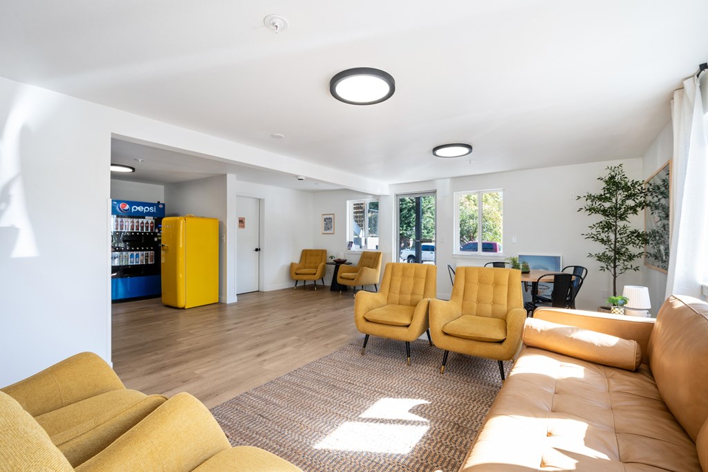 A living room with yellow chairs and a brown rug.