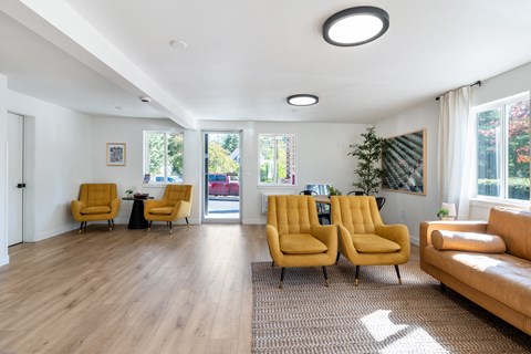 A living room with yellow chairs and a brown couch.