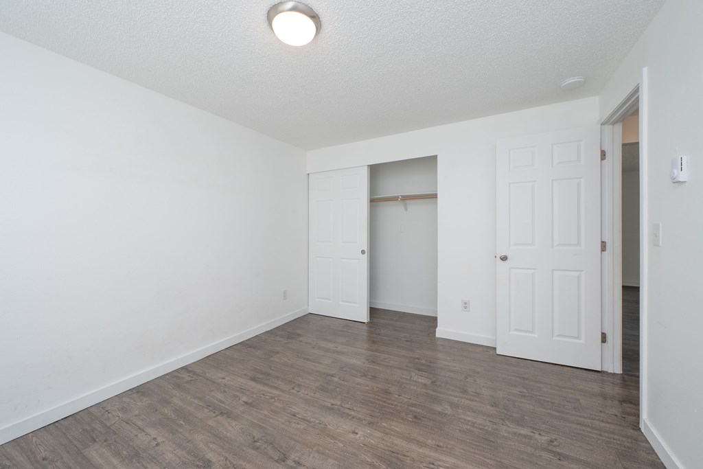 A room with a white door and a light on the ceiling.