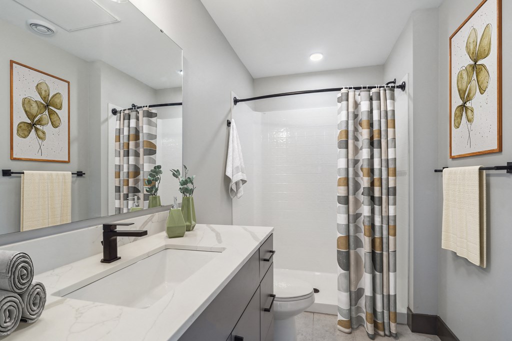 Modern bathrooms with bathtub and shower at Alta Crossing Apartments.